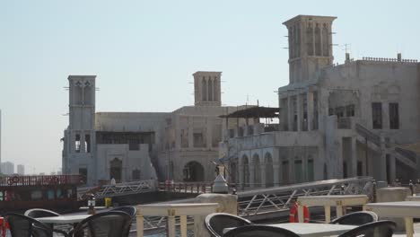 Edificios-Frente-Al-Mar-Con-Torres-De-Viento-En-El-Distrito-Histórico-De-Al-Fahidi,-Dubai,-Emiratos-árabes-Unidos---Tiro-Lateral