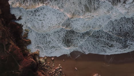 Aerial-top-view-of-waves-at-Nazare-beach-in-Portugal-during-sunset