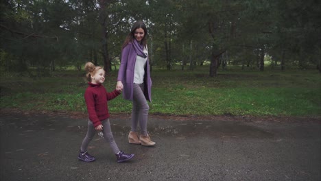mother and daughter walking in a park on a rainy day