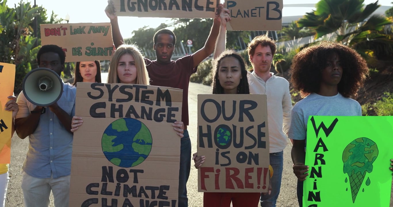 Grupo diverso de jóvenes protestando contra el cambio climático con carteles