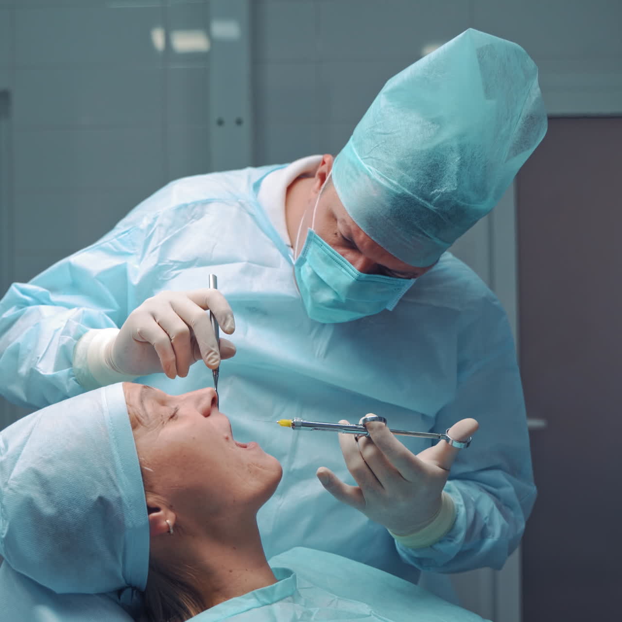 Dentist in medical clothes is doing anesthetic injection in the sick tooth. Stomatologist man treating female patient in the dentist office. Stomatology anesthesia
