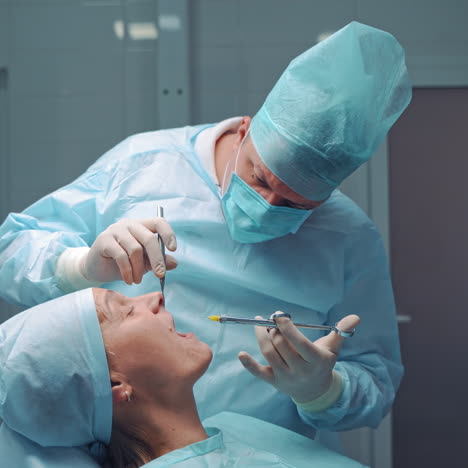 dentist in medical clothes is doing anesthetic injection in the sick tooth. stomatologist man treating female patient in the dentist office. stomatology anesthesia