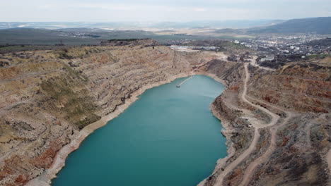 aerial view of a quarry with a turquoise lake