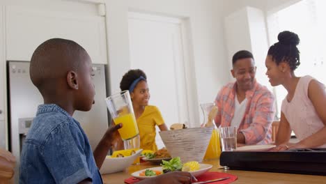 Vorderansicht-Einer-Glücklichen-Schwarzen-Familie,-Die-Auf-Dem-Esstisch-In-Einem-Komfortablen-Zuhause-4K-Isst