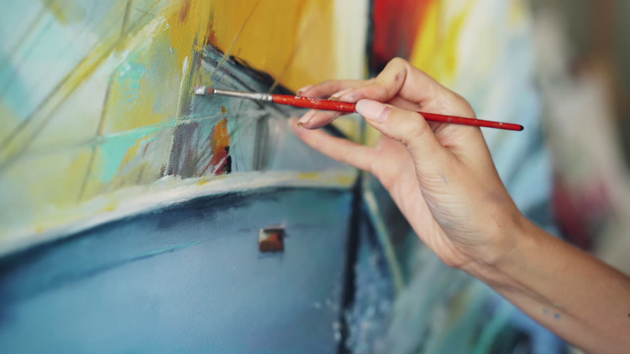 Primo piano di un artista che dipinge un'opera astratta