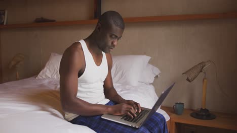 african american using computer in bedroom