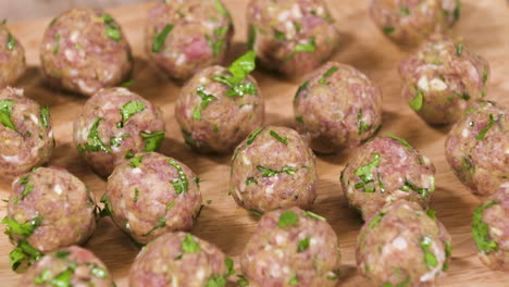 forming and preparing small pork meatballs with fresh herbs, bunch of small raw meatballs