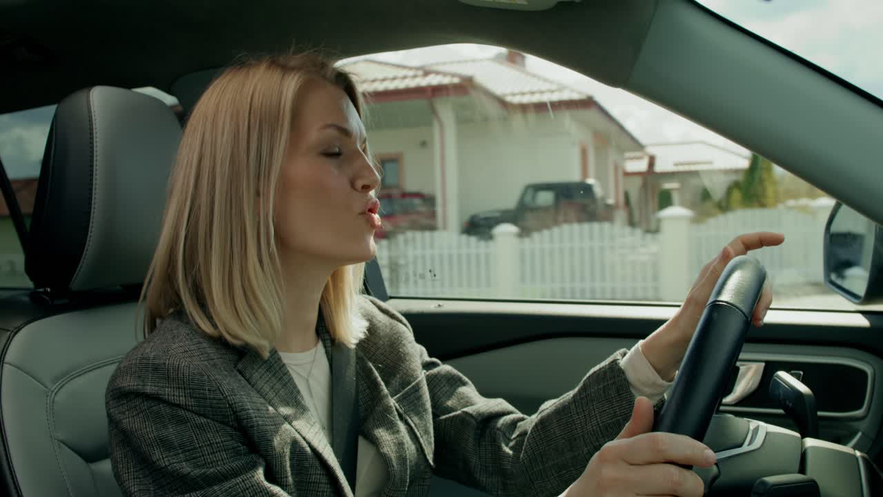 mujer conduciendo un coche en los suburbios