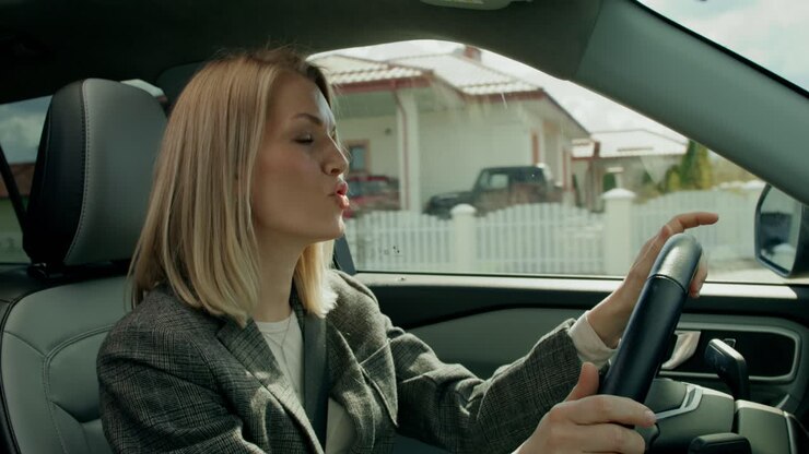 Donna che guida un'auto in periferia