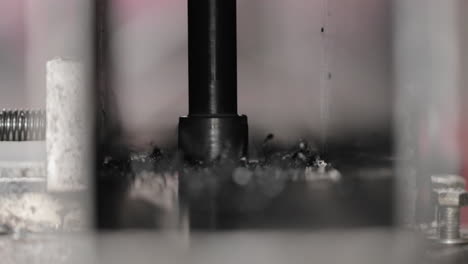 automated iron piercing machine drilling hole - closeup shot