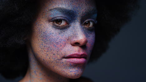 Nahaufnahme-Eines-Porträts-Einer-Schönen-Afroamerikanerin-Mit-Exotischer-Gesichtsbemalung,-Geheimnisvoller-Körperkunst-Mit-Buntem-Make-up,-Blinkendes-Licht-Im-Dunklen-Hintergrund,-Kreatives-Ausdruckskonzept