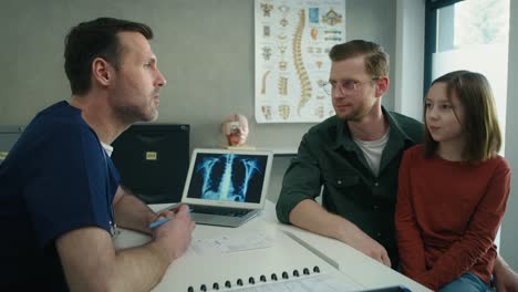 caucasian father and daughter on visit at a general practitioner