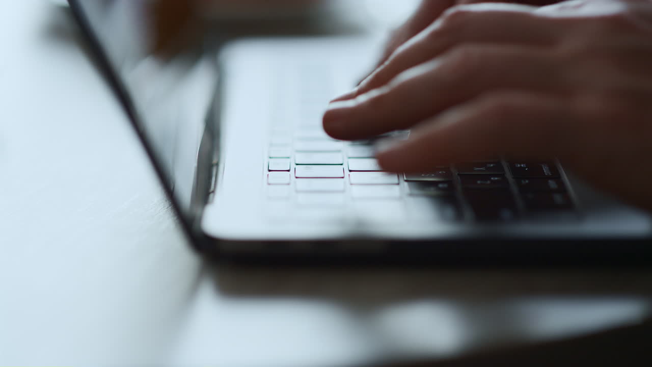 manos escribiendo en el teclado de la computadora portátil trabajando en un proyecto de negocios en línea sentado en una cafetería.
