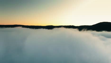 Stunning-areal-view-of-mountains-covered-by-clouds,-drone-is-flying-through-clouds