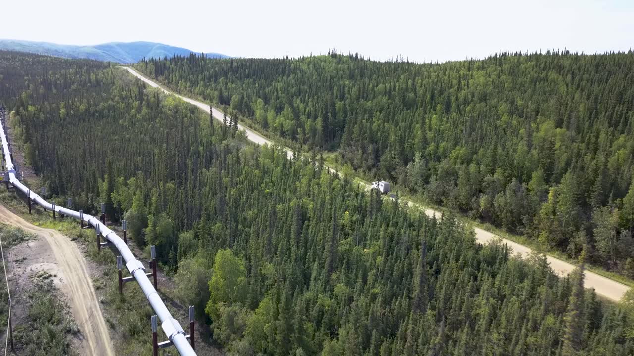 paisaje de alaska - conducción de automóviles en la carretera junto a la tubería, vista de seguimiento aéreo