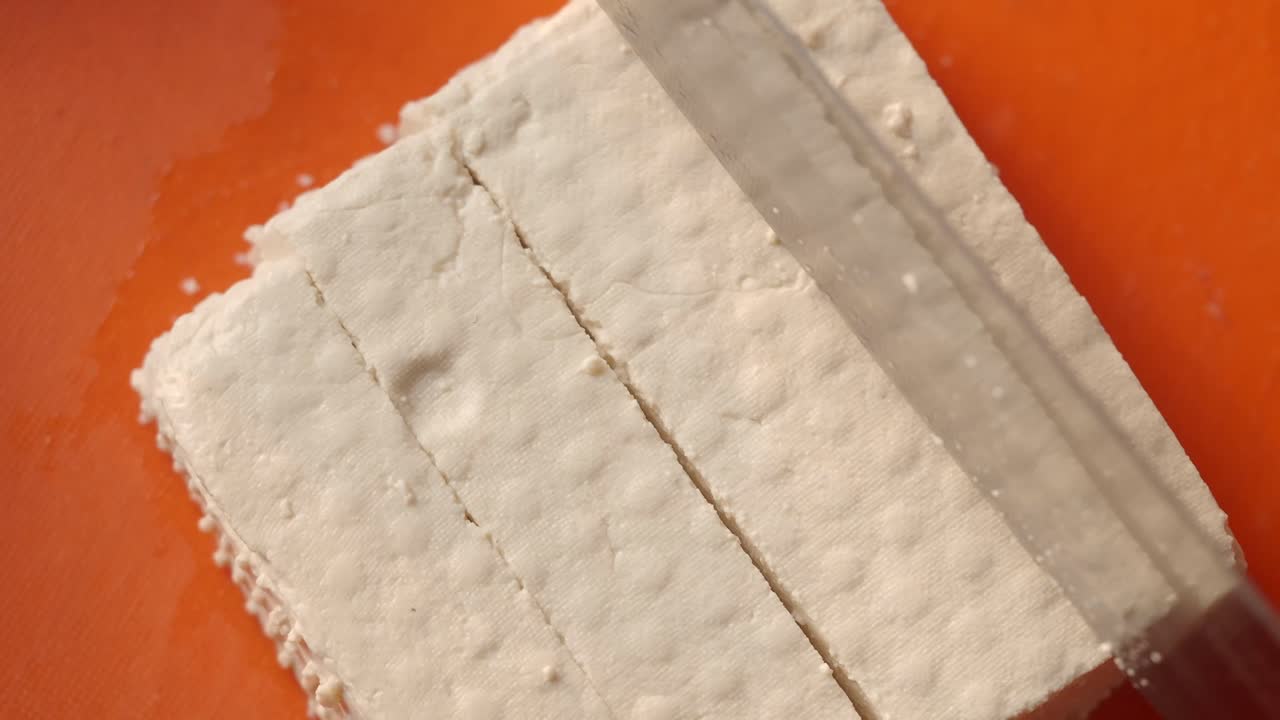tofu en rebanadas en un plato de naranja