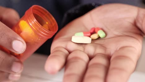 person holding pills and bottle