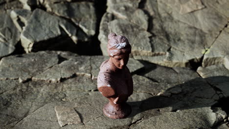 ancient-statue-of-woman-on-rocky-stones