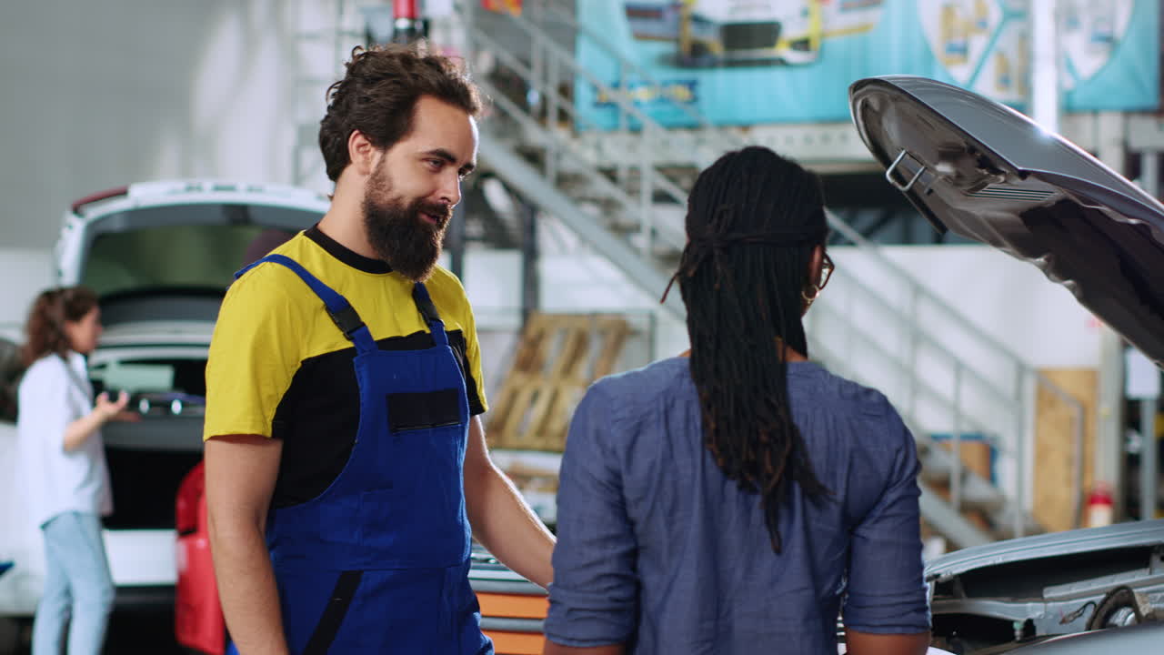 mecánico mostrando los daños en el coche del cliente