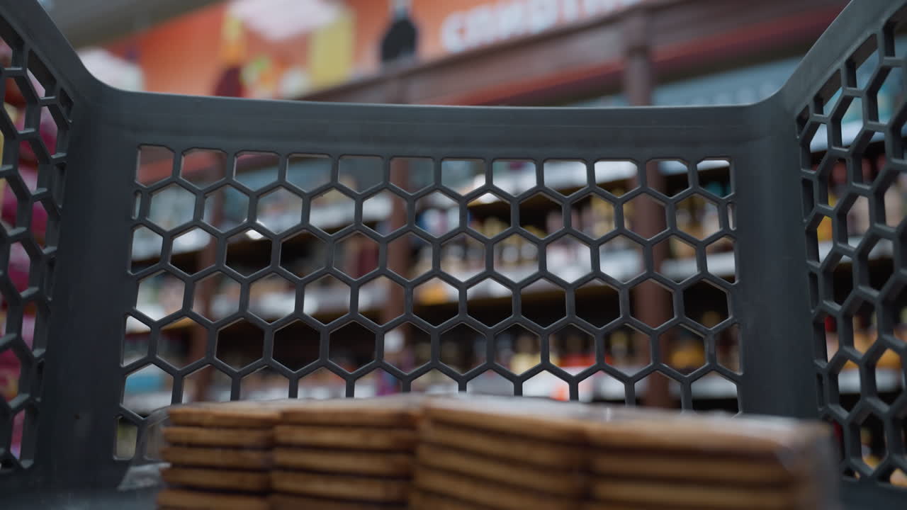 vista de una persona moviendo un carrito de compras con un paquete de galletas dentro. filmado con una cámara portátil, capturando la experiencia de compras desde la perspectiva del carrito en una tienda de comestibles