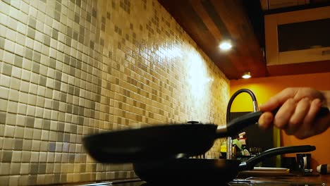 las imágenes muestran algunos espárragos cocinados y volcados en una sartén en una pequeña cocina con encimera y armarios de cocina visibles en el fondo y en primer plano en 4k en estonia, filmado en europa