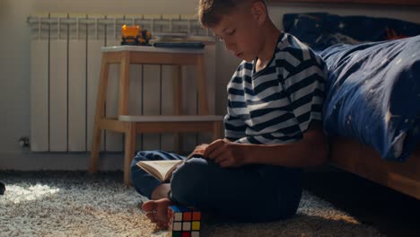 young boy reading a book in his bedroom