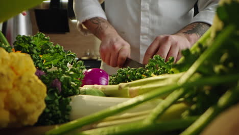 chef cutting vegetables in kitchen