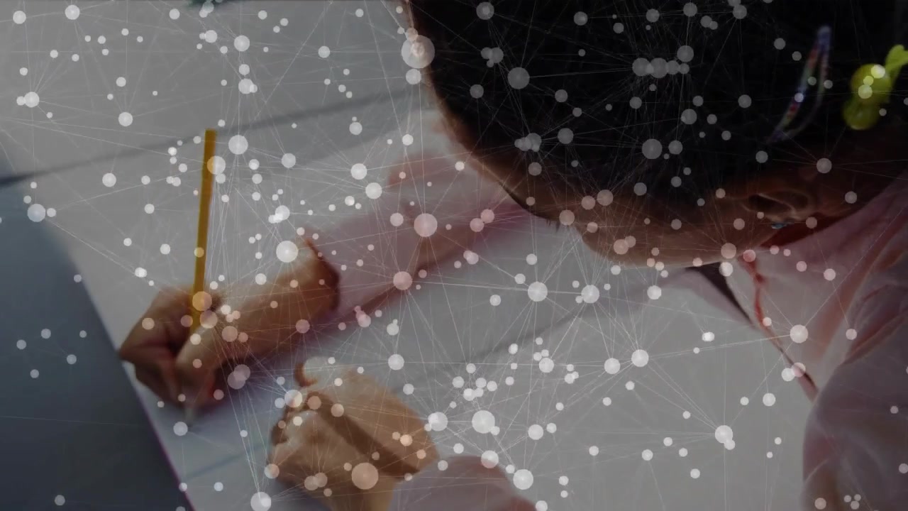 Picking up yellow pencil, schoolgirl tracing letters across notebook beside laptop for education