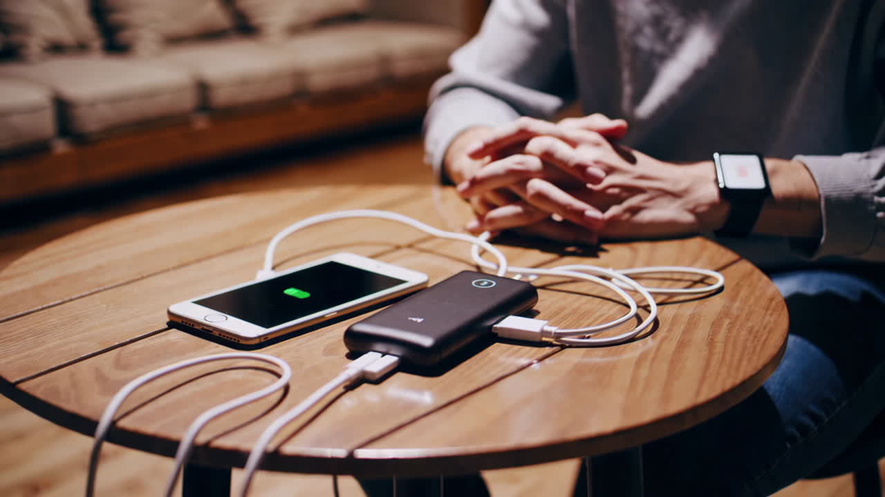 Person Charging Smartphones with a Power Bank