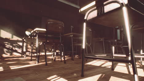 view to classroom with tables and small blackboard and grungy walls