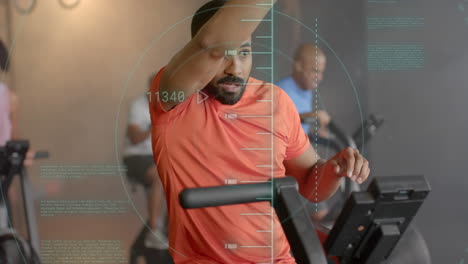 animación de datos de procesamiento de escáner sobre hombre biracial entrenamiento cruzado en elíptico en el gimnasio