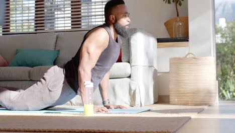 focused african american man practicing yoga at sunny home, slow motion