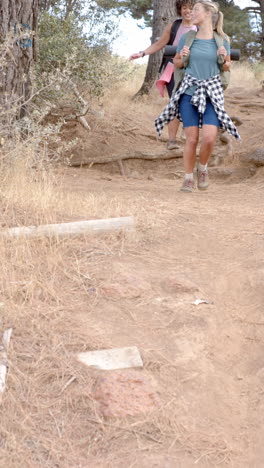 vertical video: hiking on trail, two women with backpacks enjoying outdoor adventure
