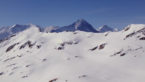 imágenes aéreas de drones de invierno de abajo hacia arriba que revelan fiescherhoerner, la cara norte del eiger y jungfrau en suiza