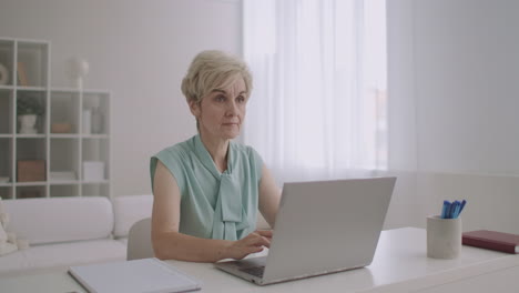 Eine-Blonde-Frau-Mittleren-Alters-Kommuniziert-In-Sozialen-Netzwerken-Per-Laptop-Und-Tippt-Nachrichten-Auf-Der-Tastatur-Ein