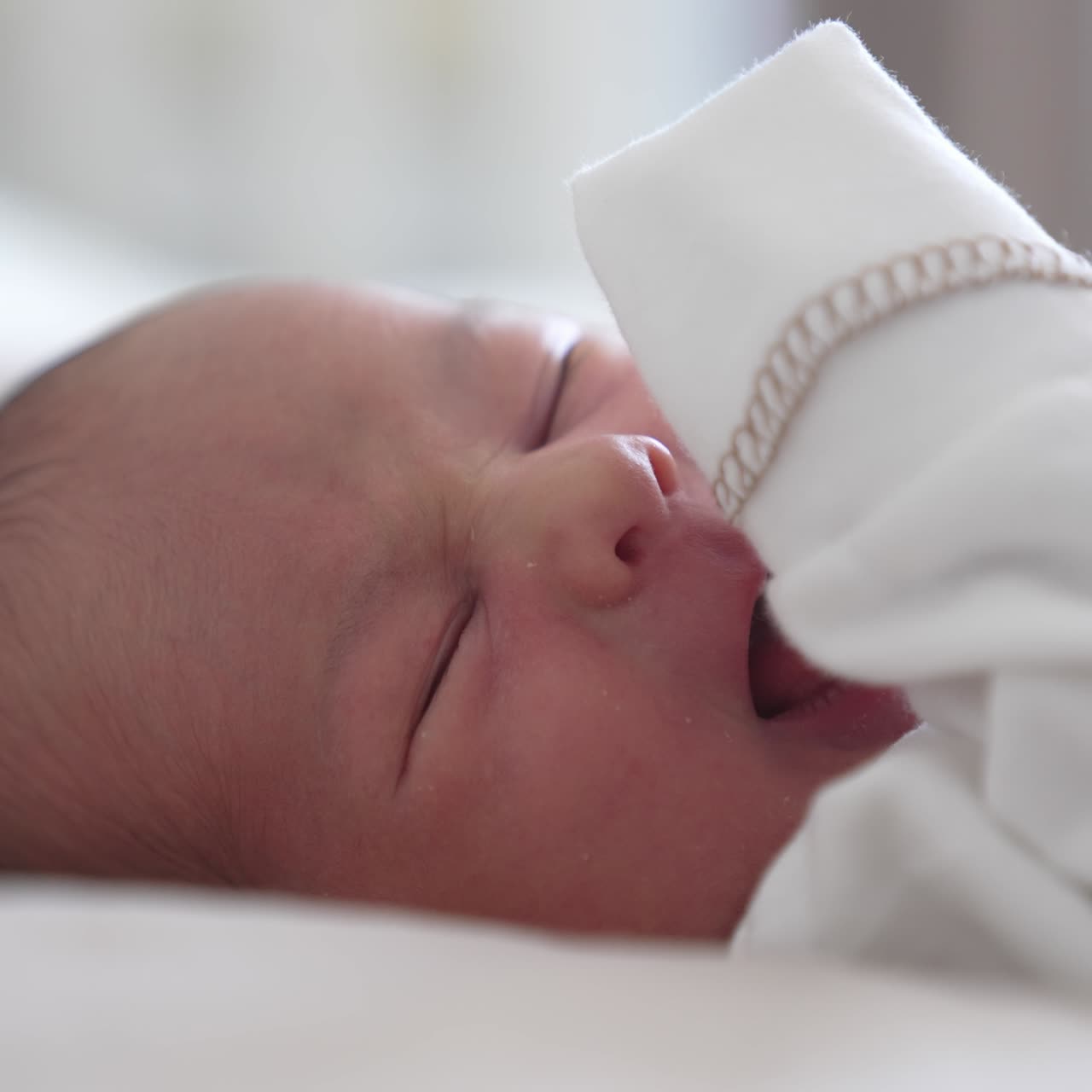 Neonato divertente. Adorabile neonato che dorme e sbadiglia sul letto. Splendido bambino a casa. Primo piano