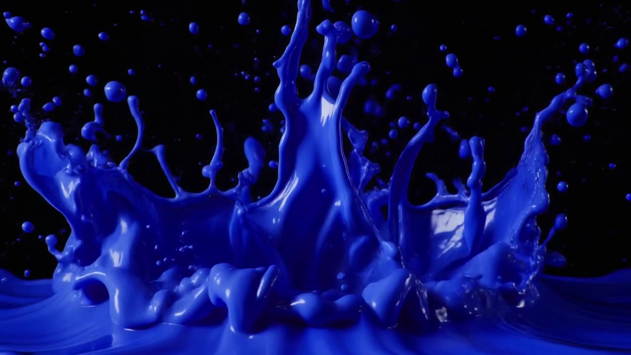 Pintura azul salpicando sobre un fondo negro