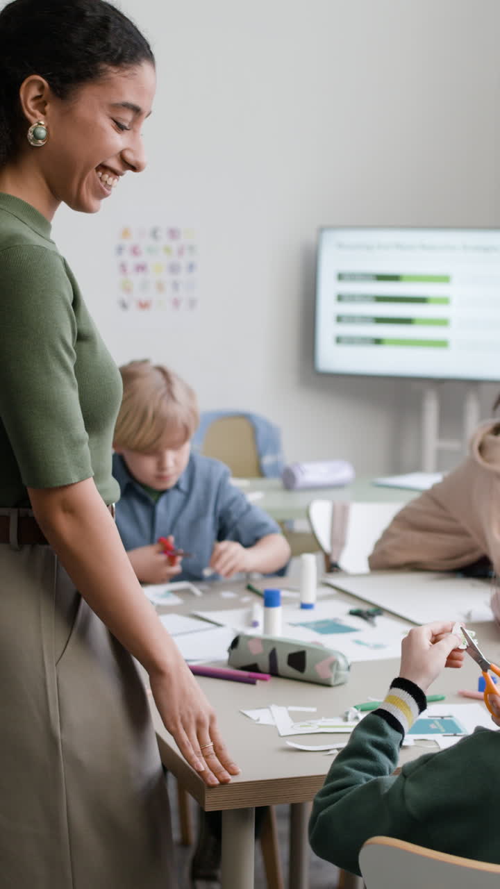 Teacher Assisting Students with Arts and Crafts in Class
