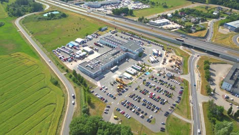 aerial view of the logistics park with warehouse, loading hub and many semi trucks with cargo trailers standing at the ramps for load unload goods at sunset