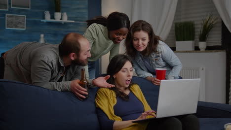 multi-ethnic friends watching interesting comedy movie on laptop computer