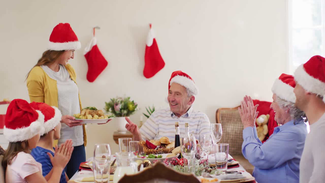 mujer caucásica en sombrero de santa sirviendo comida a toda la familia