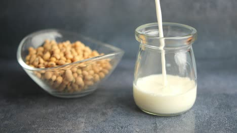 soy milk pouring into a glass jar