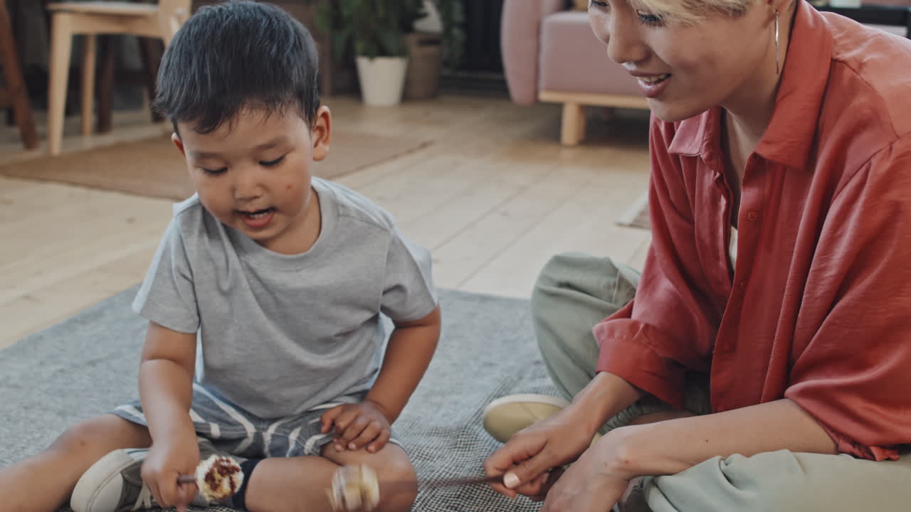 Asian Mother with Son Playing Glucophone Together