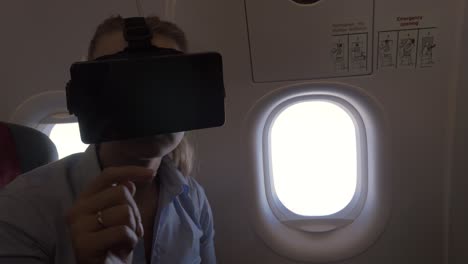 view of woman using vr-helmet for smartphone in airplane