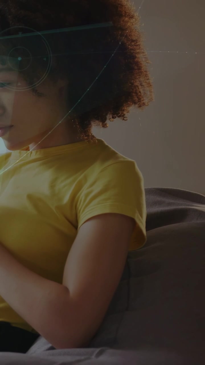 Video verticale: Donna sul divano che tocca il telefono, testa l'interfaccia utente tecnologica, con archi luminosi che orbitano attorno alla spalla.