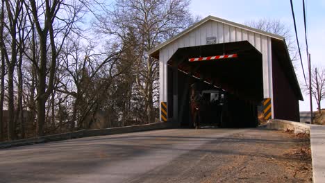 An-Amish-horse-cart-travels-through-a-covered-bridge-along-a-road-in-rural-Pennsylvania-3