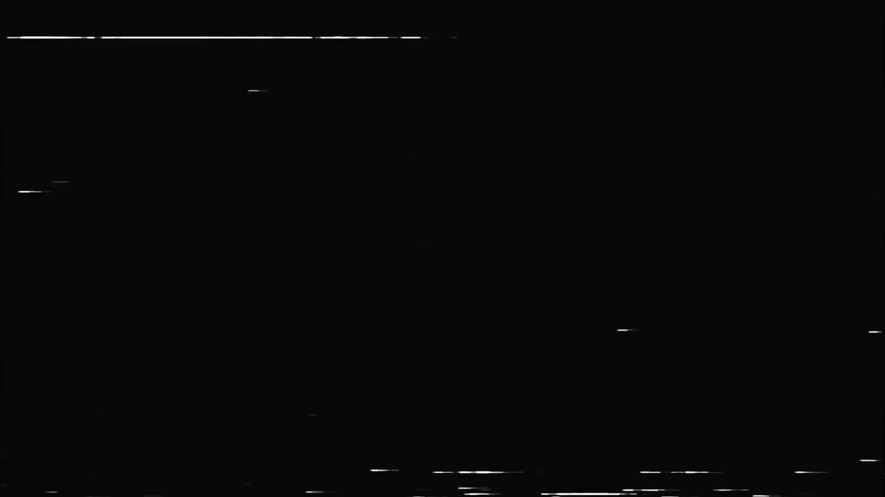 Linee bianche tratteggiate e puntini sparsi si muovono su uno sfondo nero, simulando polvere leggera o piccoli danni al nastro magnetico.