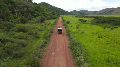 Tracking-Drohnenaufnahme-Eines-Lastwagens,-Der-Sich-Auf-Einer-Unbefestigten-Straße-In-Der-Ländlichen-Landschaft-Von-Guyana,-Südamerika,-Bewegt