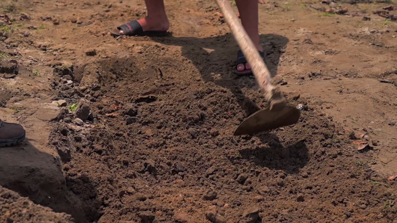 Man working with a shovel in soil, preparing land in a rural Amazonian village