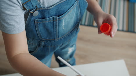 child painting with orange paint